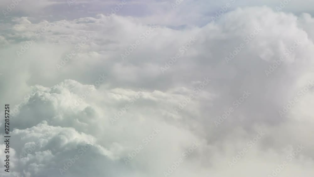 View from the plane at moving snow white clouds. Sky background. The Heaven. Flying on an airplane among the clouds. Tranquil background View from the plane at moving snow white clouds. Sky background. The Heaven. Flying on an airplane among the clouds. Tranquil background