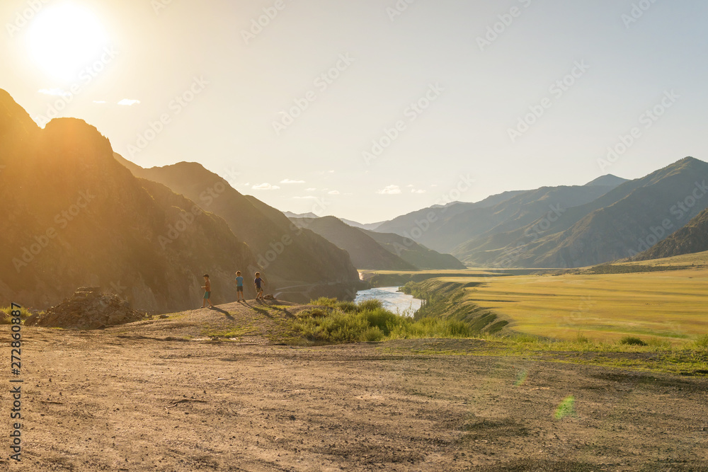 sunny summer landscape with children in the sun against the backdrop of mountains and rivers