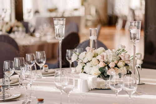 Wedding in the style vintage. Decoration of the table with flowers and cutlery. Composition from flowers. Elegant dining table in peach-purple color. Indoors wedding reception venue with festive decor