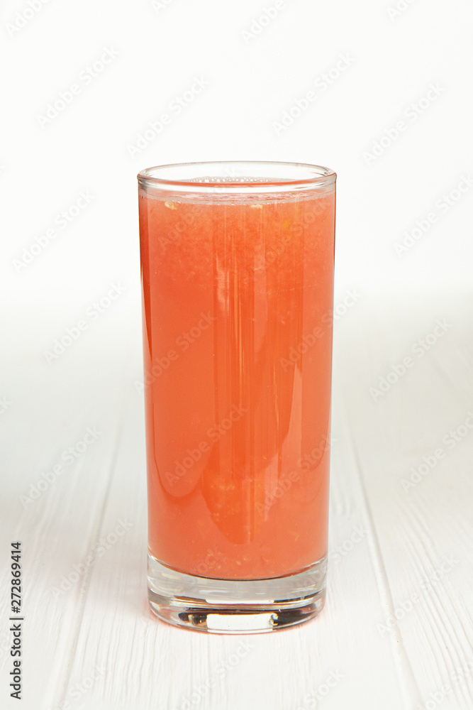 large thin transparent glass filled with cold summer drink freshly prepared juice is photographed on a white wooden table isolated background picture for the menu large thin transparent glass filled with cold summer drink freshly prepared juice is photographed on a white wooden table isolated background picture for the menu