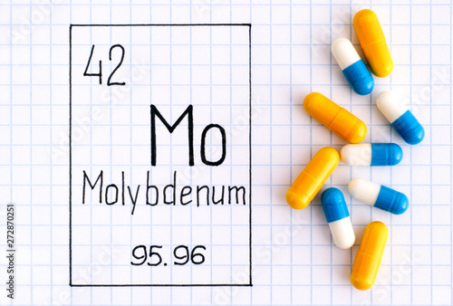 Handwriting chemical element Molybdenum Mo with some pills.