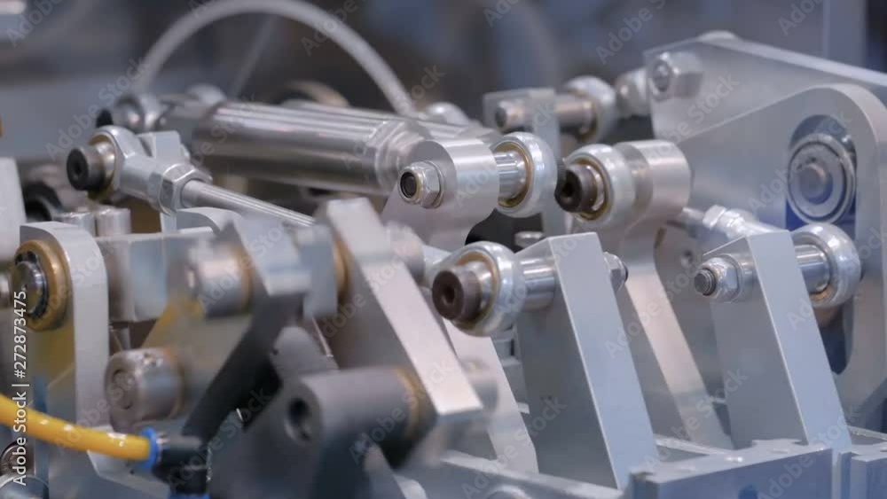 Close up view - moving parts of hydraulic industrial automotive machine tool equipment. Abstract industry, engineering, machinery, manufacturing, production process and automated technology concept Close up view - moving parts of hydraulic industrial automotive machine tool equipment. Abstract industry, engineering, machinery, manufacturing, production process and automated technology concept