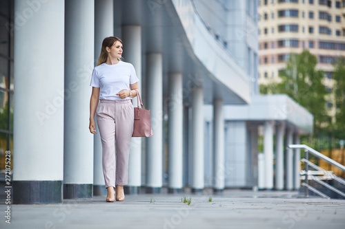 Free Download girl in pants goes near the business building. - GFXLoad