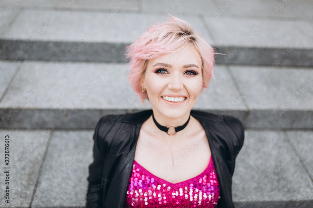 Street urban portrait of young hipster caucasian stylish sexy cheerful gorgeous woman in black suit and pink dress smiling. Happiness, fashion, beauty, freedom concept. Grey color background Street urban portrait of young hipster caucasian stylish sexy cheerful gorgeous woman in black suit and pink dress smiling. Happiness, fashion, beauty, freedom concept. Grey color background
