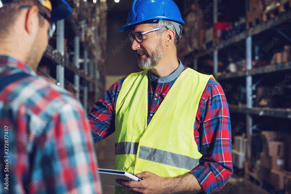 Fototapeta premium Two workers in uniforms in warehouse