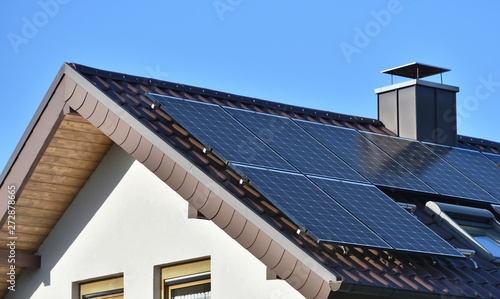 Valokuva Solar panels installed on the roof of a house with tiles in Europe against the background of a blue sky