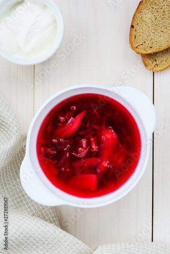 Plate of borsch on a white wooden table. National russian food.