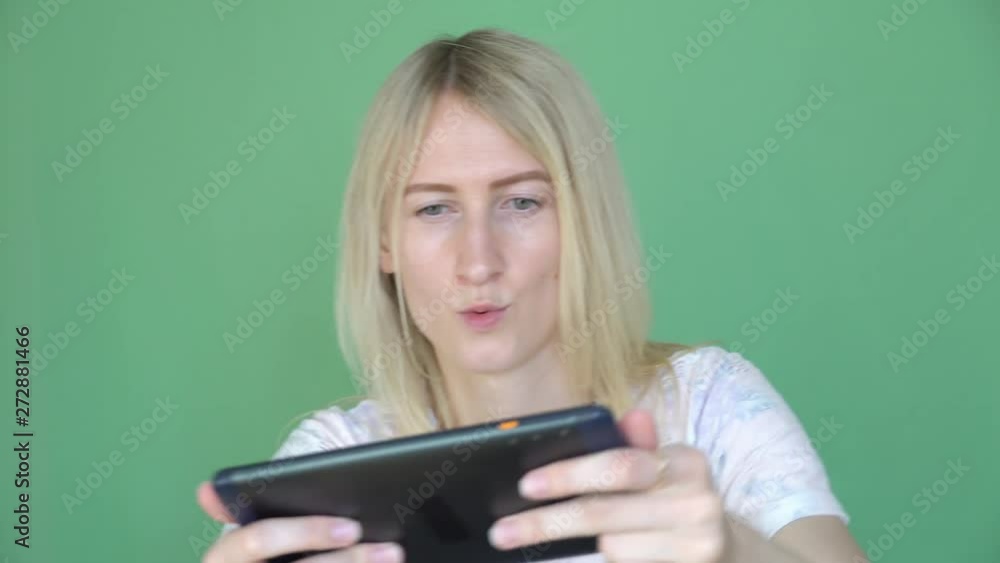 Funny woman playing game on digital tablet. Chroma Key background. modern technology concept. Funny woman playing game on digital tablet. Chroma Key background. modern technology concept.