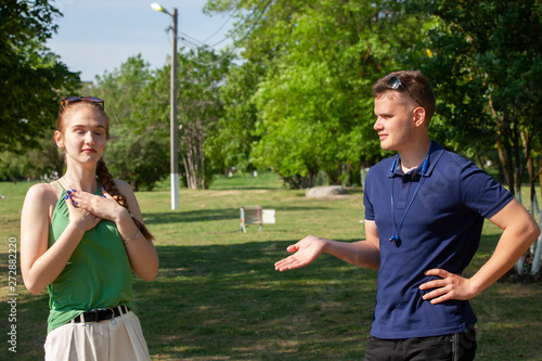 Young couple arguing while sitting on bench in park. Problems in relationship