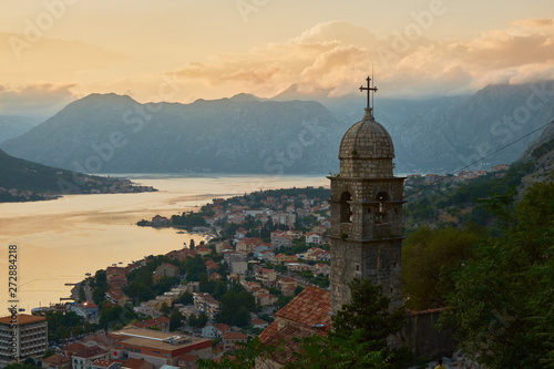 View of the old city from a height at sunset in the background of the mountains in the sky with clouds.