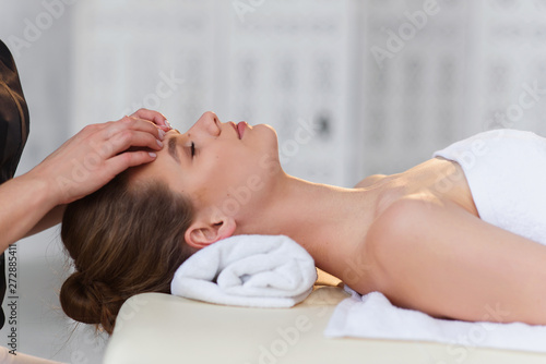Young caucasian woman getting spa treatment in the modern white salon.