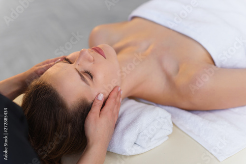 Young masseur making massage for young female client.