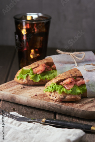 Tasty salmon sandwich with salad