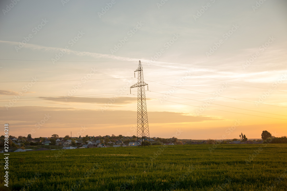 high voltage towers against sunrise