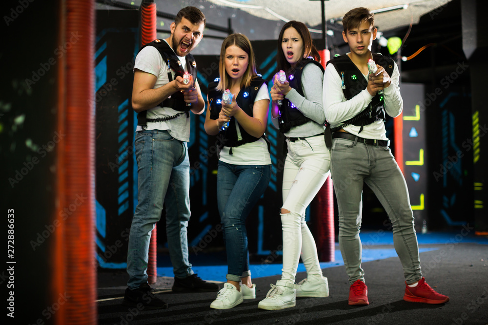 Friends with laser guns in lasertag room
