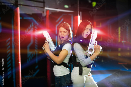 Girls back to back in colorful laser beams