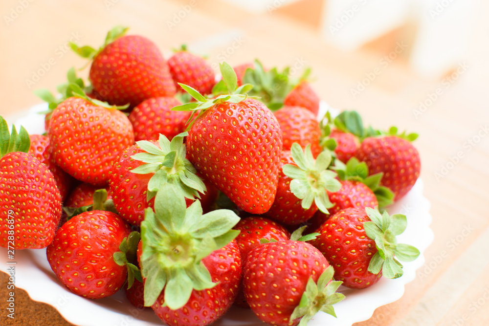 Fresh strawberries on a white plate.