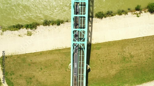 Train crossing green railway bridge over Sava river in Zagreb, Croatia, from drone, aerial view photo