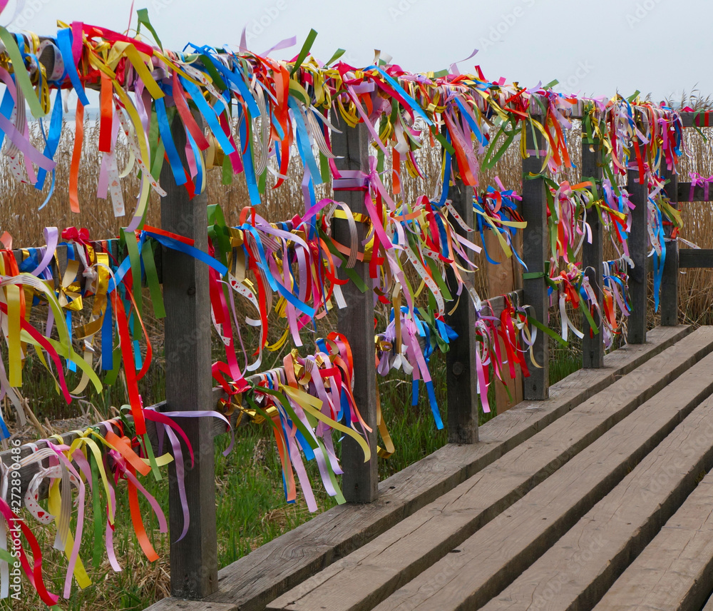 Funny multicolored ribbons on the fence in the wind selective focus and blurred background