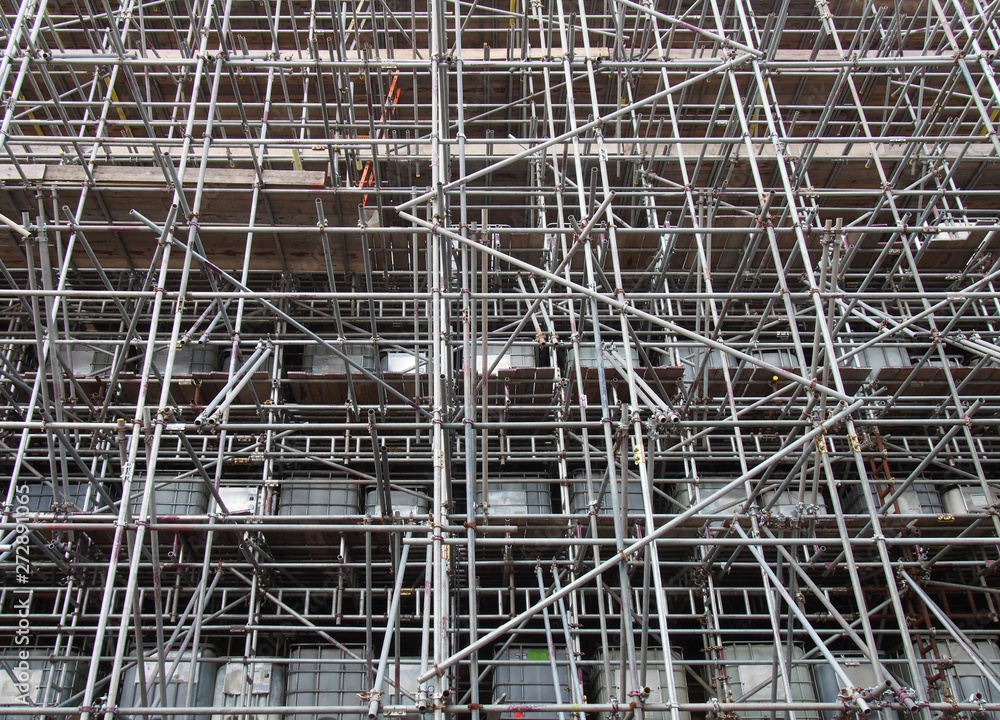 scaffolding on a construction siteshowing ibc water filled intermediate bulk containers used as ballast on each level