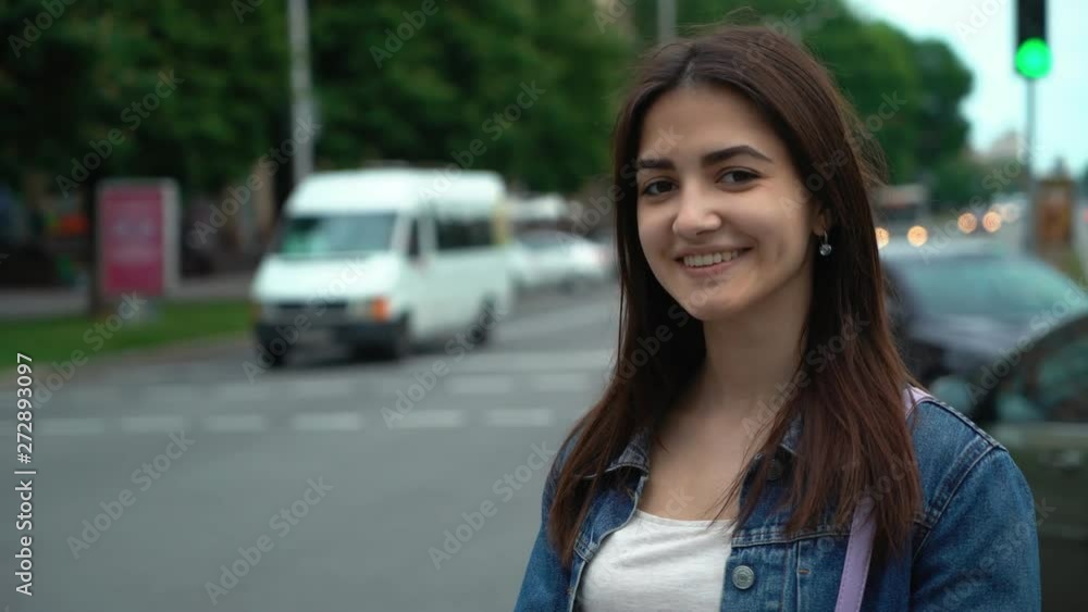 young beautiful brunette girl standing on the car road in a city young beautiful brunette girl standing on the car road in a city