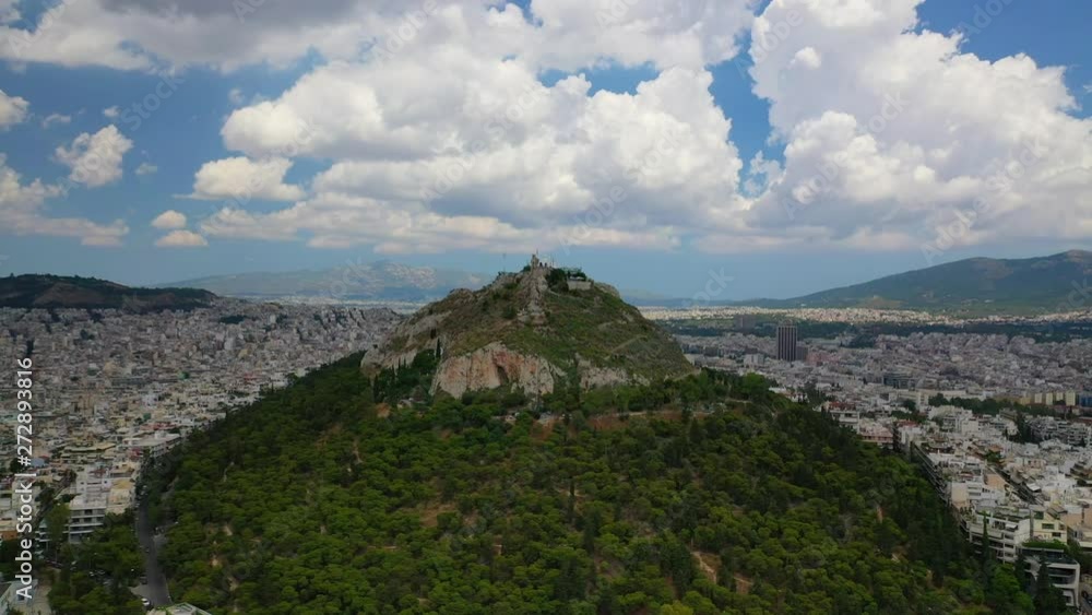 Aerial drone video of iconic Mount Lycabettus featuring famous church of Saint George on top with beautiful clouds and deep blue sky, Athens historic centre, Attica, Greece Aerial drone video of iconic Mount Lycabettus featuring famous church of Saint George on top with beautiful clouds and deep blue sky, Athens historic centre, Attica, Greece