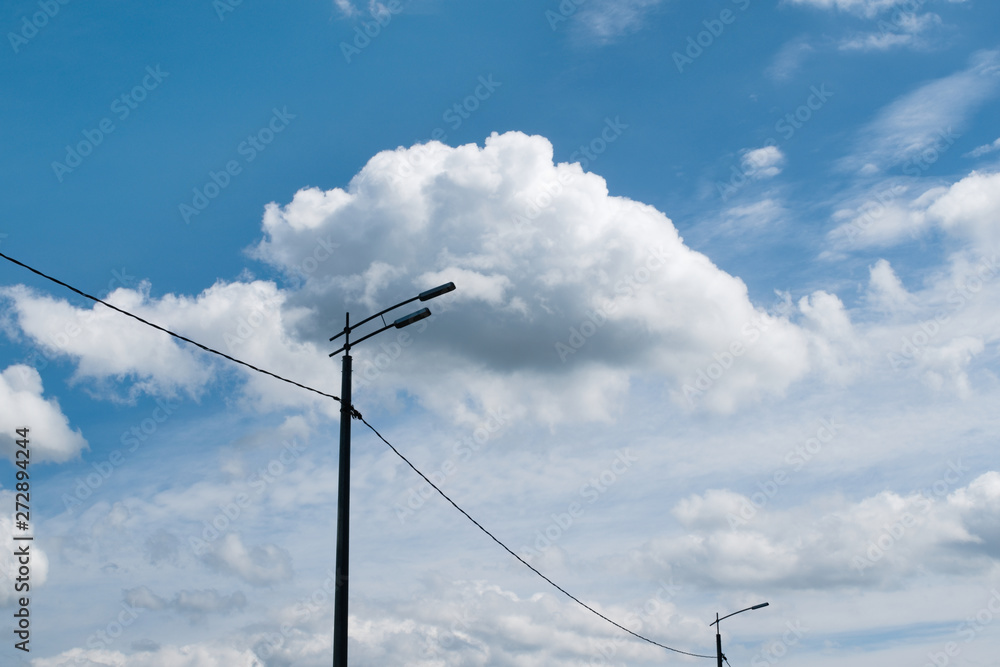 A night lamp combined with a cloud illuminated by sunlight. A fluffy cloud in a bright blue sky adds to the fullness of the picture. A night lamp combined with a cloud illuminated by sunlight. A fluffy cloud in a bright blue sky adds to the fullness of the picture.