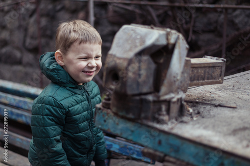 Little boy in front of a vise for metal. photo