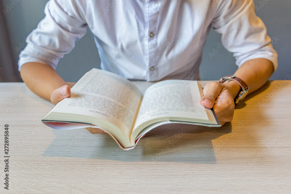 Close up of young man holding reading book Close up of young man holding reading book