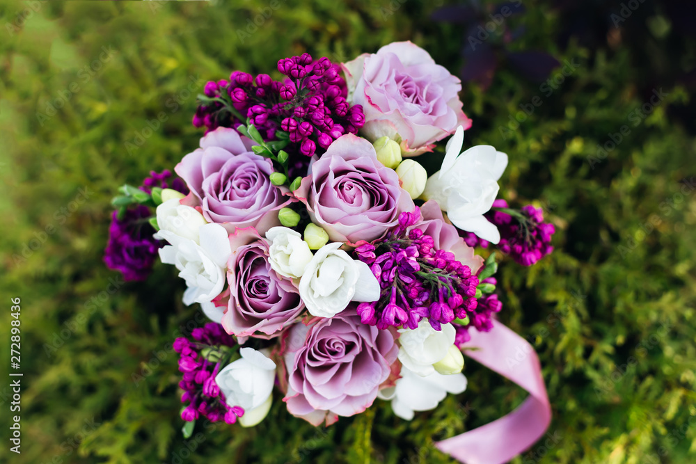 Top view of a wedding bouquet of roses and lilacs on the backgro