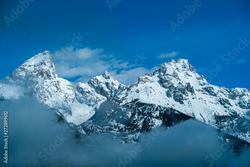 Snow-covered rocky mountain peaks surrounded by misty clouds  © Elizabeth