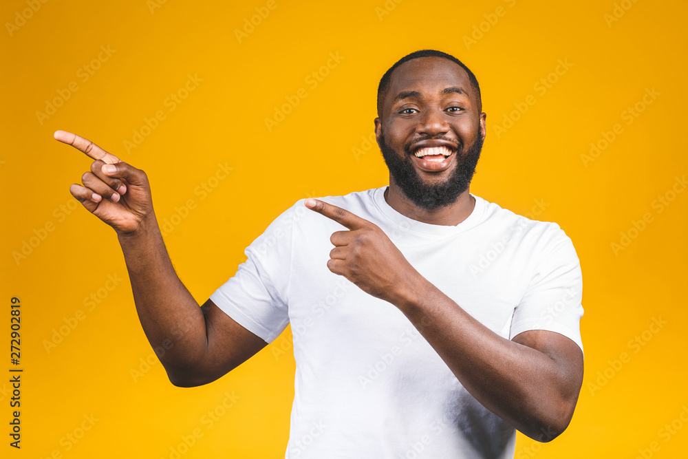 Afro american man over isolated background amazed and smiling to the camera while presenting with hand and pointing with finger. Afro american man over isolated background amazed and smiling to the camera while presenting with hand and pointing with finger.
