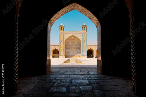 Iran mosque viewed through dark gate 