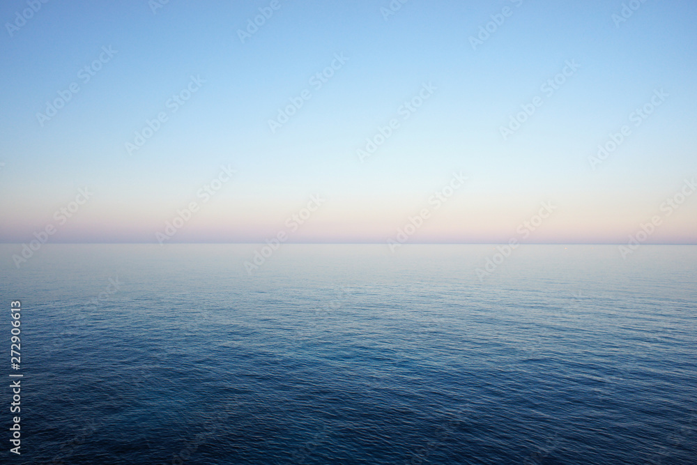 Seascape in delicate pastel colors with the horizon of the sea and clear sky early in the morning. Mediterranean Sea