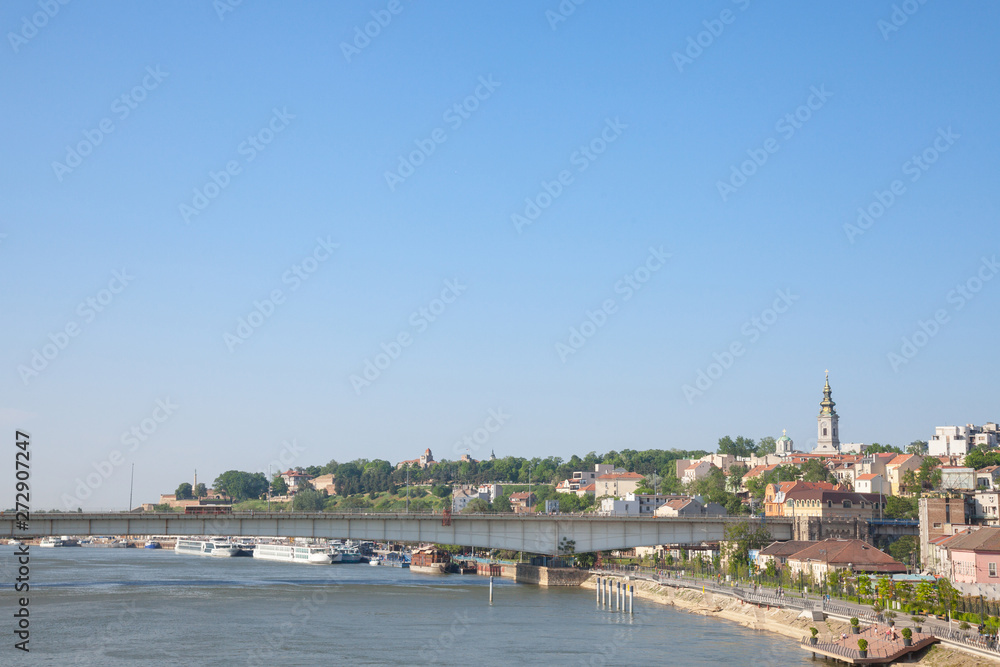 View of Sava river bank in Belgrade. An orthodox cathedral church can be seen on the right, Kalemegdan fortress on the background, and brankov most bridge in front