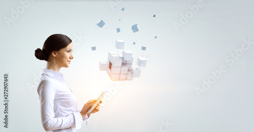 Businesswoman holding a tabalet with cube puzzle. Mixed media photo