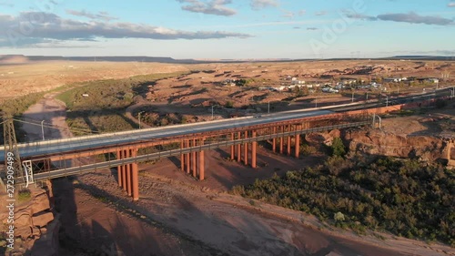  Aerial view of town Cameron, Arizona, United States.  Drone flying over suspension  bridge, highway, dry river. Sunny weather, sunset. photo