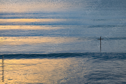 Concepts or concepts about darkened Christians standing in a vast sea or ocean There is a golden ring from the sun shining. As a guide from God