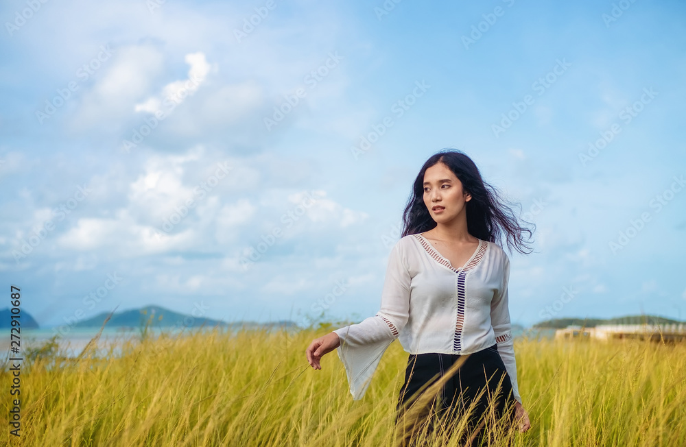Long haired woman wearing a Bohemian shirt. Stroll in the green grass fields, bright sky. Long haired woman wearing a Bohemian shirt. Stroll in the green grass fields, bright sky.
