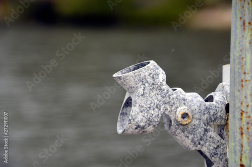 closeup of old weathered flag holder on a pier