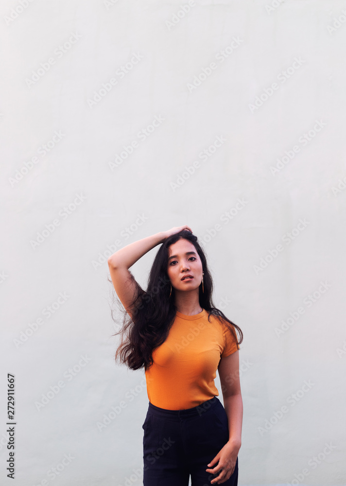The girl has a skin color of honey or tan. Wearing orange shirt Street photography poses on rooftop and orange light The girl has a skin color of honey or tan. Wearing orange shirt Street photography poses on rooftop and orange light