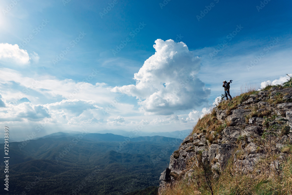 Silhouette of man hold up hands on the peak of mountain,success concept Silhouette of man hold up hands on the peak of mountain,success concept