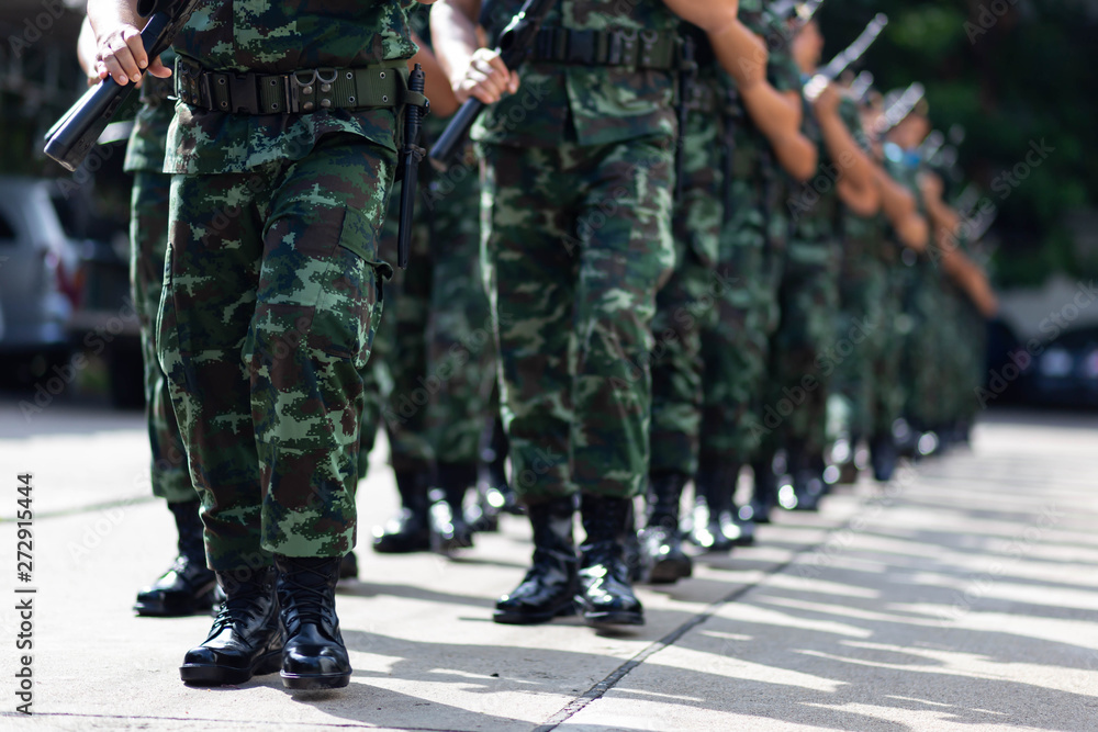 iron discipline of the best soldiers in army, a column of soldiers in uniform and with modern automatic weapons in hands of boots marching. iron discipline of the best soldiers in army, a column of soldiers in uniform and with modern automatic weapons in hands of boots marching.