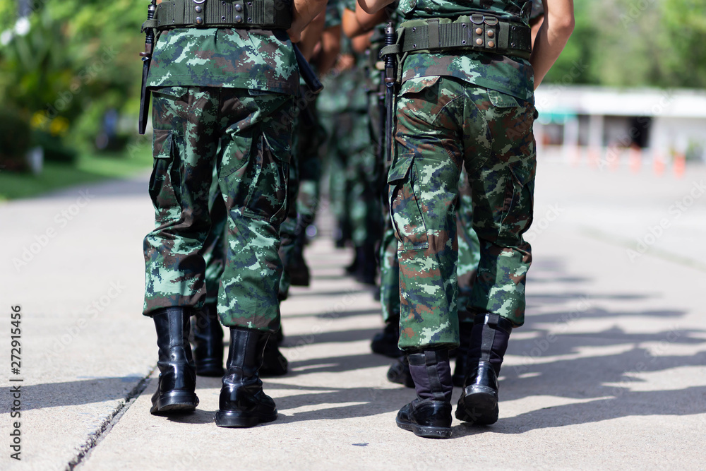 iron discipline of the best soldiers in army, a column of soldiers in uniform and with modern automatic weapons in hands of boots marching.