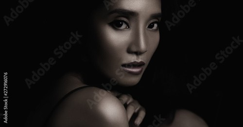 beautiful young woman closeup face and glossy skin under glamour low key concept