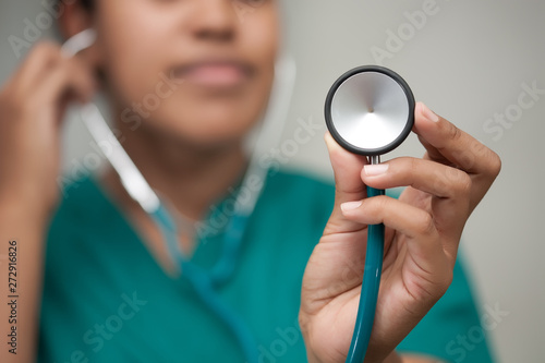 A female healthcare professional taking a reading using a stethoscope and carefully listening to form a diagnosis.