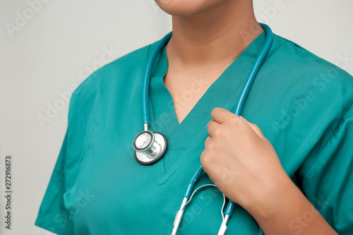 A closeup of a registered nurse with modern teal scrubs and holding a stethoscope. photo