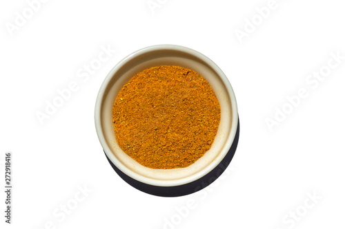 Saucer dish with ground curry isolated on white background