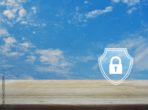 Padlock with shield flat icon on wooden table over blue sky with white clouds, Business security insurance concept