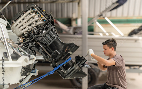 Repairing engines on aluminum boats , The technician is removing the boat parts to make the paint